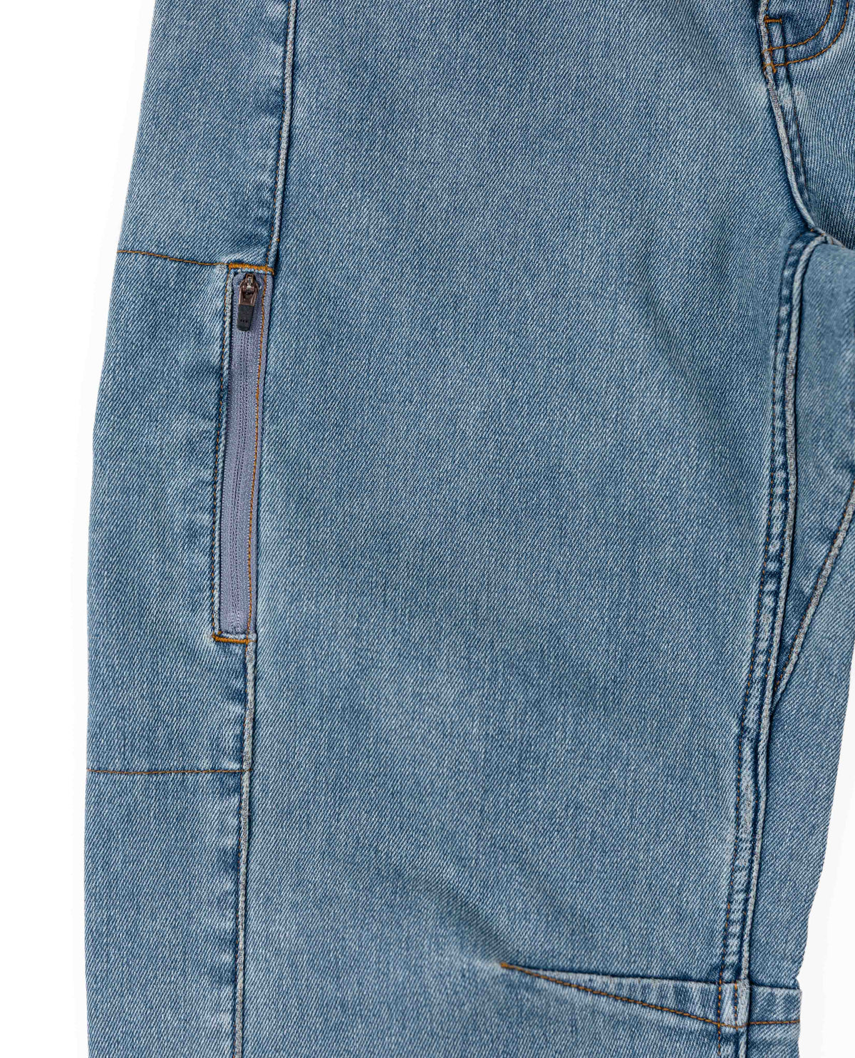 Close-up of blue denim jeans with a zipper detail on a white background
