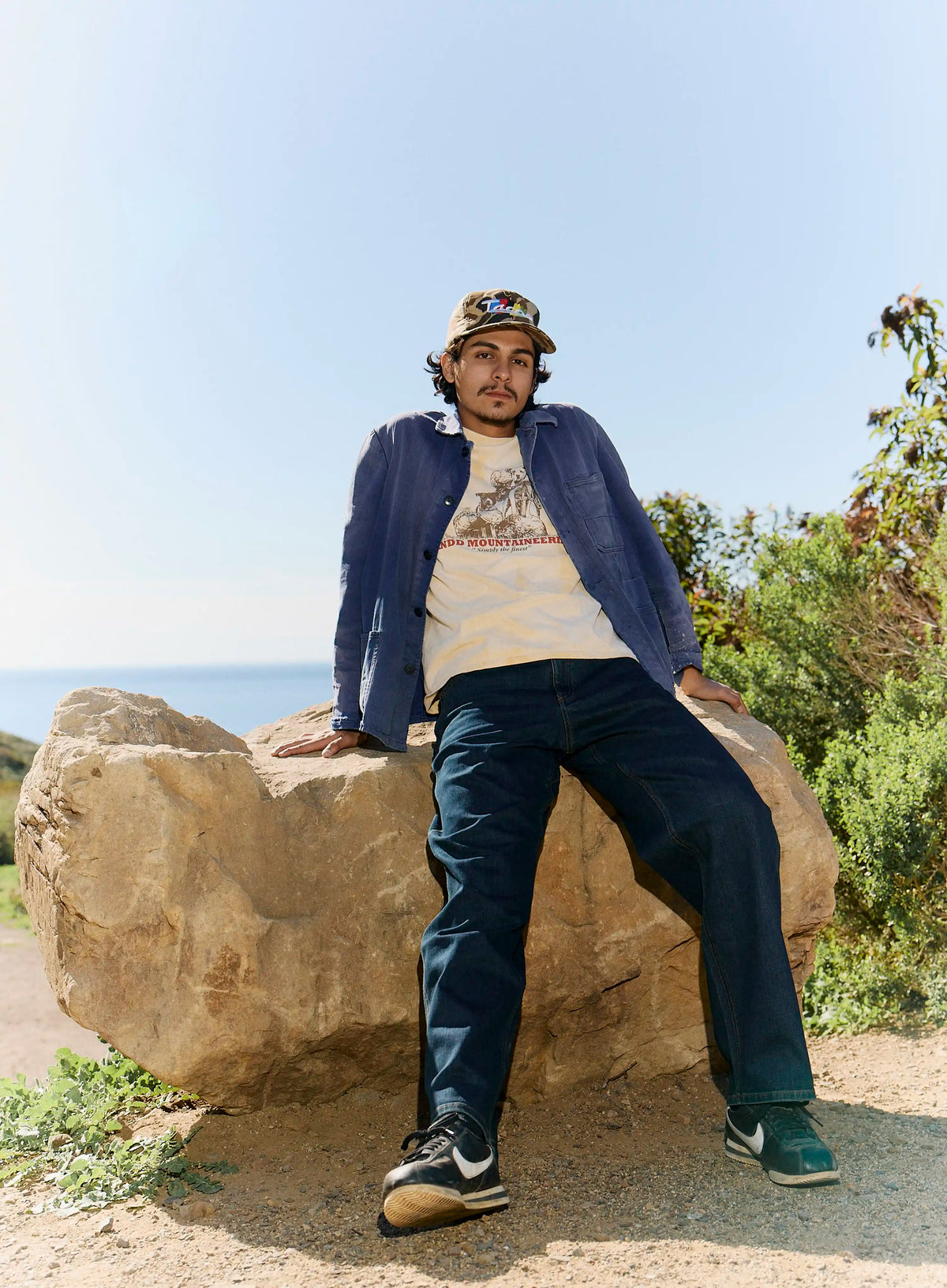 Man sitting on a rock with a scenic background