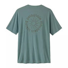 A sage green Patagonia short-sleeve t-shirt shown from the back, featuring a circular graphic with a sunburst and the brand name printed in a matching tone.