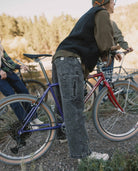 Person standing next to a bicycle with a scenic background