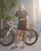 Person standing next to a bicycle with a casual pose outdoors