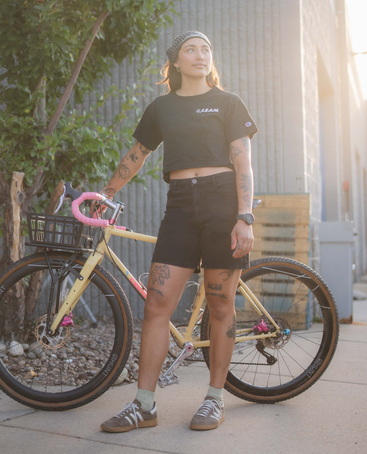 Person standing next to a bicycle with a casual pose outdoors