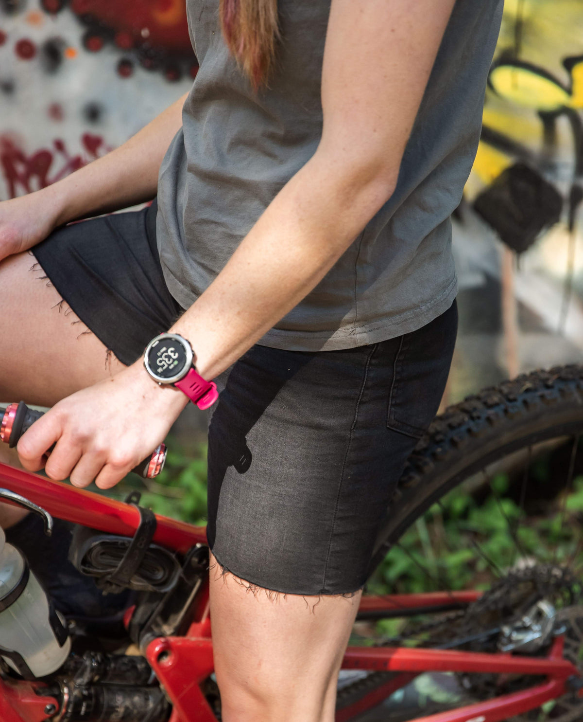 Person wearing a smartwatch with a bike in the background