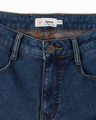 Close-up of blue jeans with a Ripton label on a white background