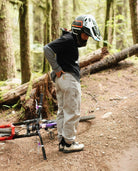 Person with a helmet and bike in a forest setting