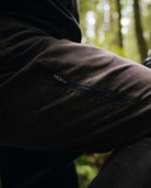 Close-up of a person wearing a dark jacket with a blurred forest background