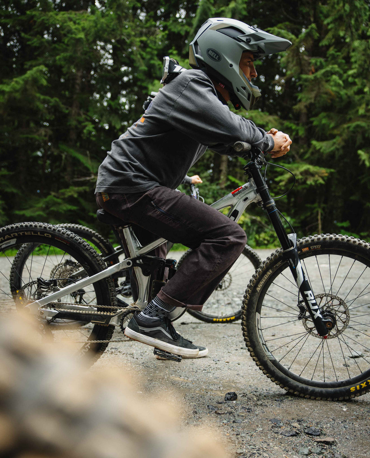 Person riding a mountain bike on a trail with trees in the background