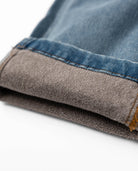 Close-up of folded denim fabric with a white background