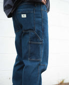 Blue jeans with a brand logo on the back pocket against a white background