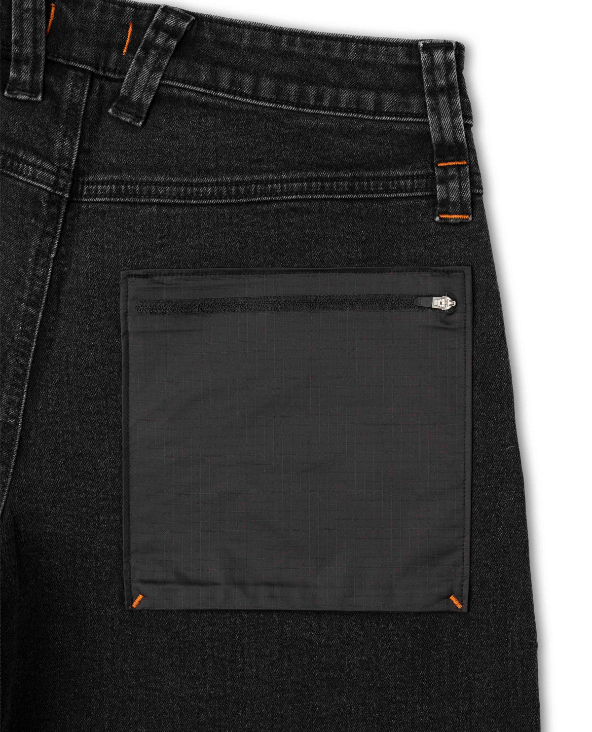 Close-up of a black denim pocket with a zipper on a white background
