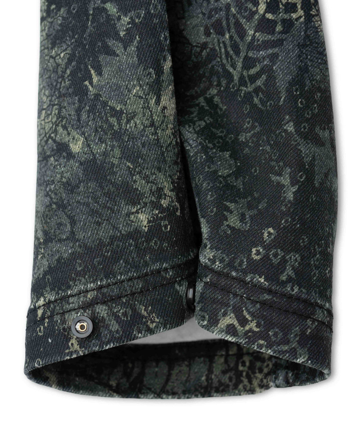 Cuff of camo pant snapped in tighter position
