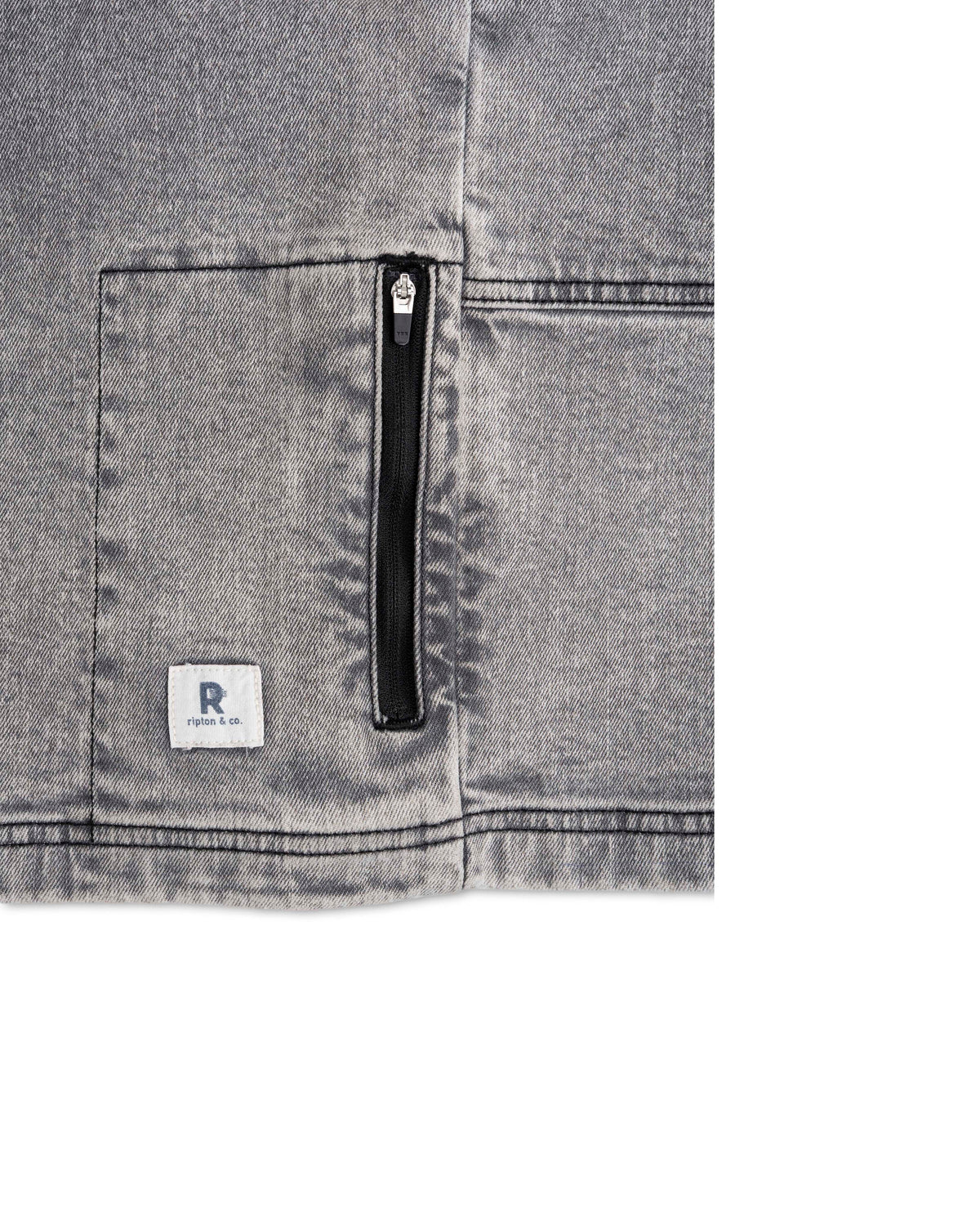 Close-up of a gray denim pocket with a zipper and brand logo on a white background