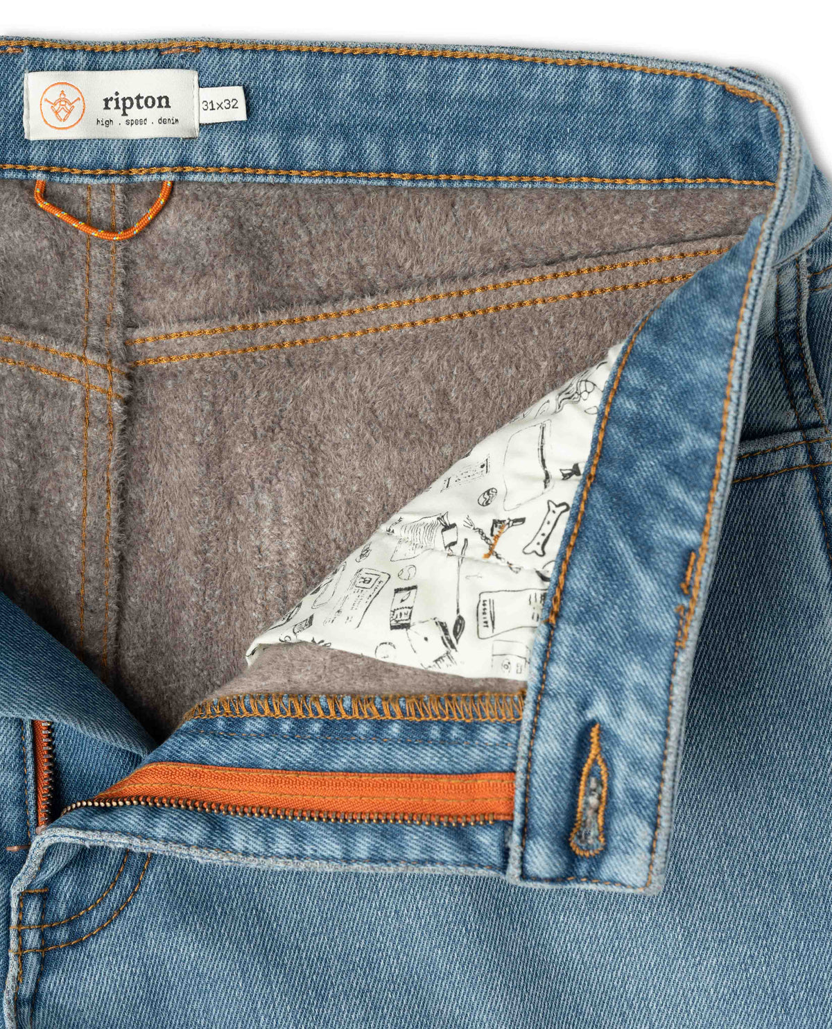 Close-up of a blue denim fabric with a patterned lining and orange stitching, featuring the Ripton brand label.