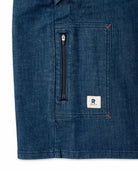 Close-up of a blue denim jacket with a zipper and brand logo on a white background