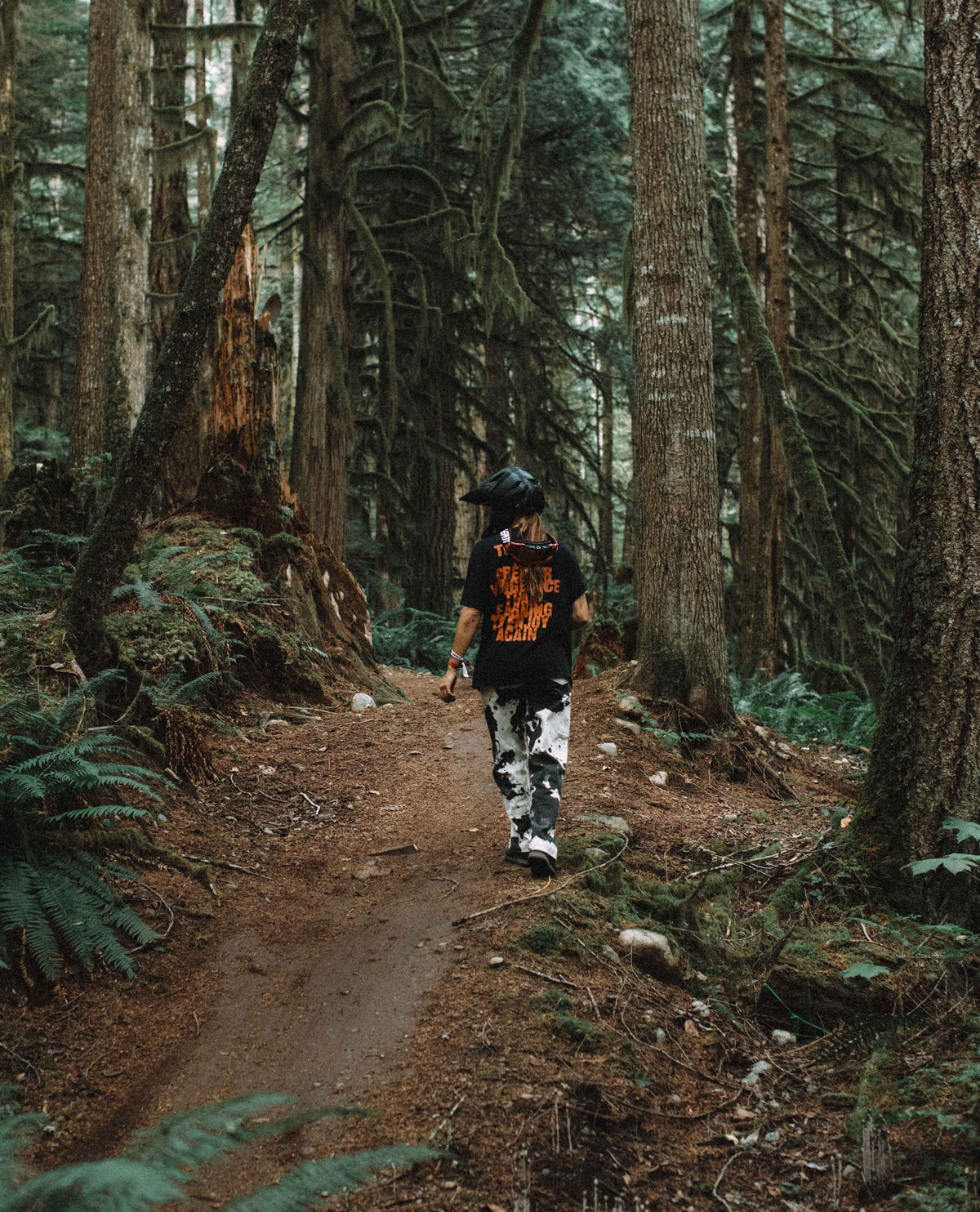 Person walking on a path through a dense forest