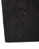 Close-up of a black denim pocket with a zipper on a white background