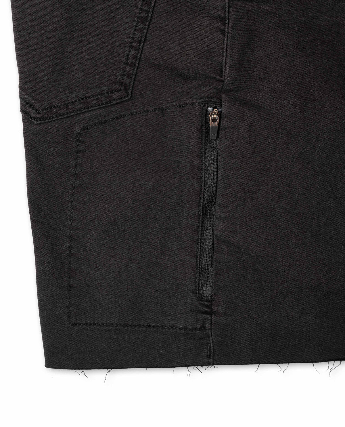 Close-up of a black denim pocket with a zipper on a white background