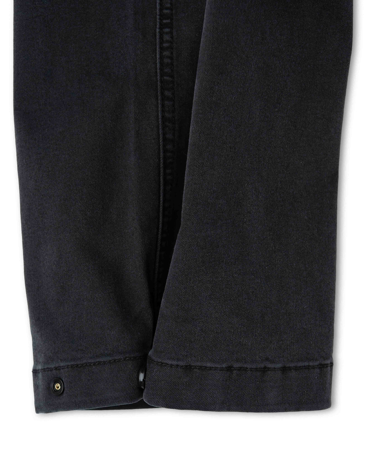 Close-up of black pants with a button on a white background