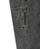 Close-up of a gray denim pocket with a zipper on a white background