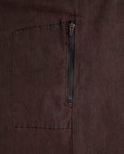 Close-up of a brown fabric pocket with a zipper on a matching brown background