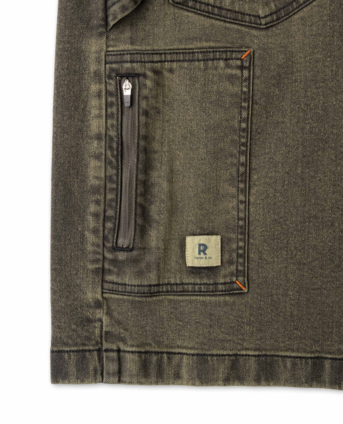 Close-up of a green denim jacket with a zipper pocket and brand logo on a white background