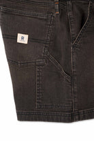 Close up of side pocket on dark brown shorts with white background 