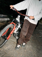 Person holding a bicycle on a dark road