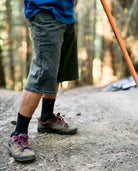 Person wearing hiking shoes and shorts on a forest path
