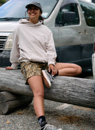 Person sitting on a log with a vehicle in the background